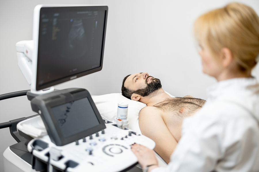 Doctor examining the liver of a male patient by doing a liver scan